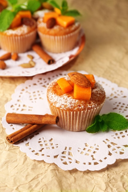 Tasty pumpkin muffins on brown paper