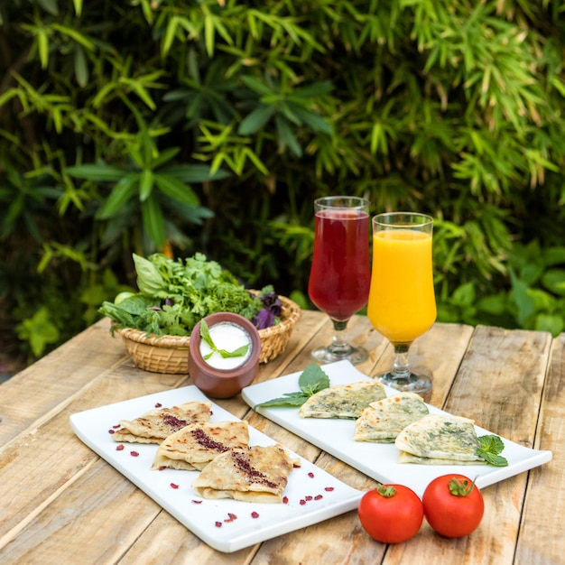 Tasty qutab, Azerbaijani meal with yogurt, juice on the wooden plate