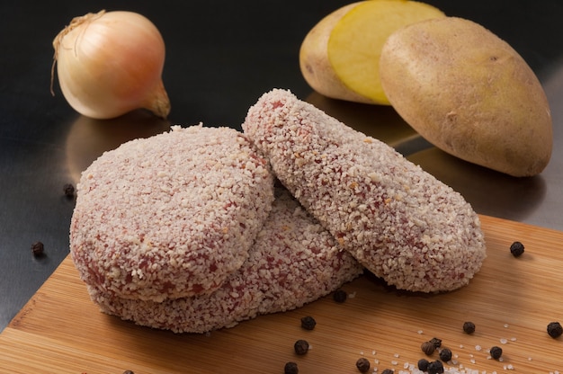 Tasty raw cutlets with meat, potatoes and onions