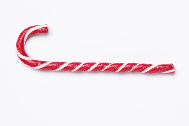 Tasty red candy cane  on white background. Festive treat