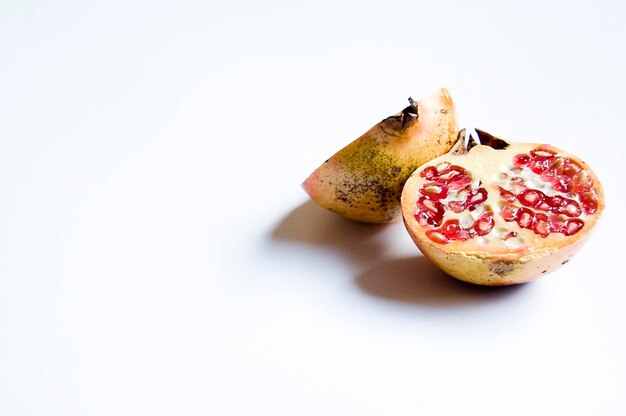 Photo tasty red healthy juicy pomegranate fruit cut in half isolated on white