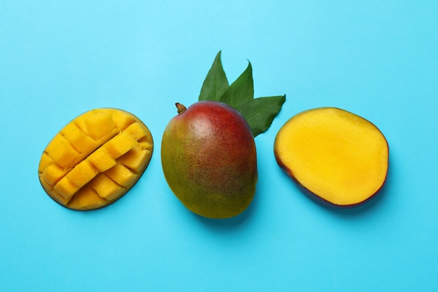 Tasty ripe mango fruit on blue background