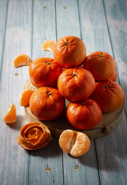 Tasty ripe tangerines on a woody background