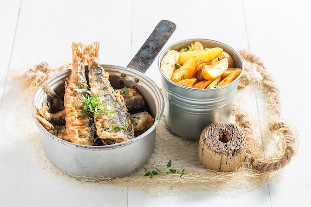 Tasty roasted herring fish with chips on white background