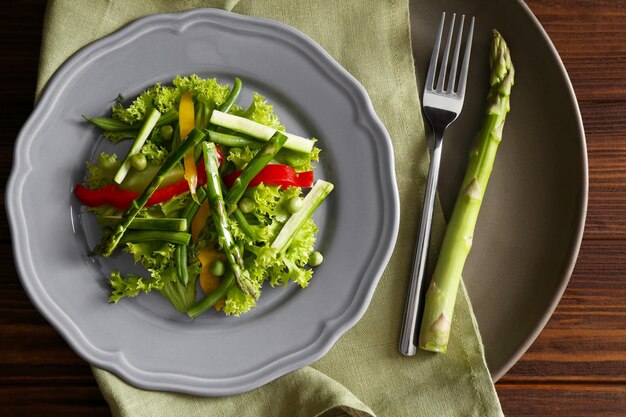 Tasty salad with asparagus and vegetables on plate