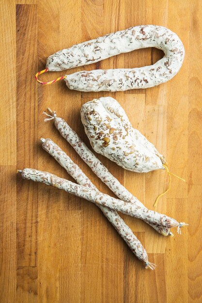 Tasty salami with white mold on kitchen table