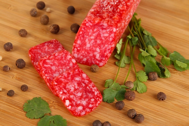 Tasty salami on wooden board closeup