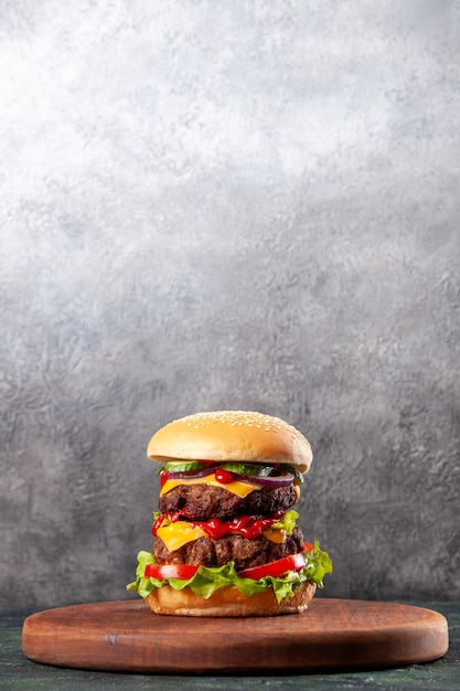 Tasty sandwich on brown wooden cutting board on ice surface