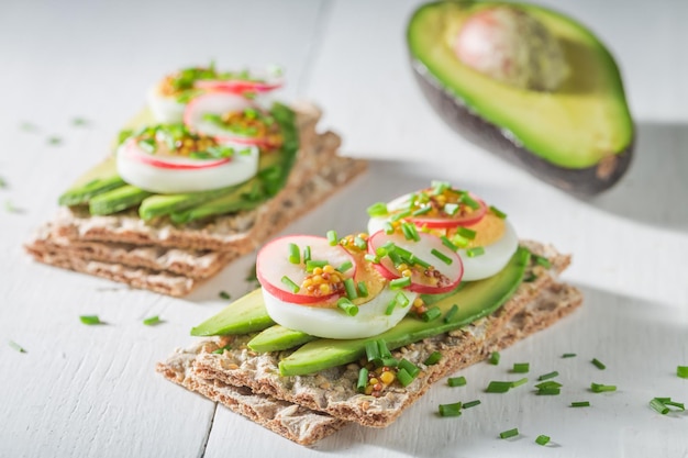 Tasty sandwich with avocado radish and eggs