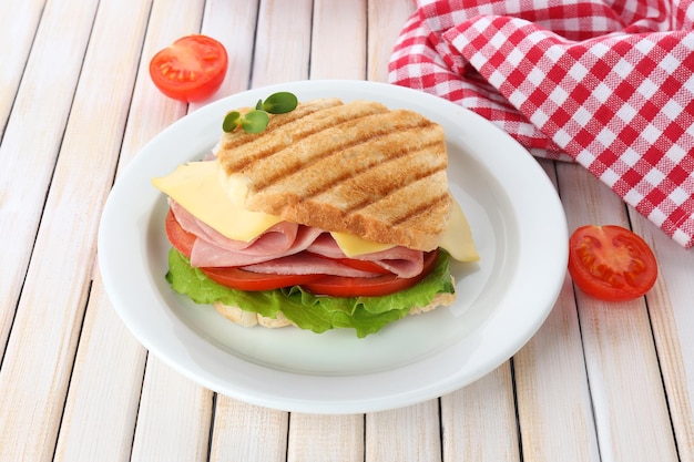 Tasty sandwich with ham on wooden table