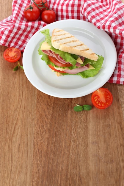 Tasty sandwich with ham on wooden table