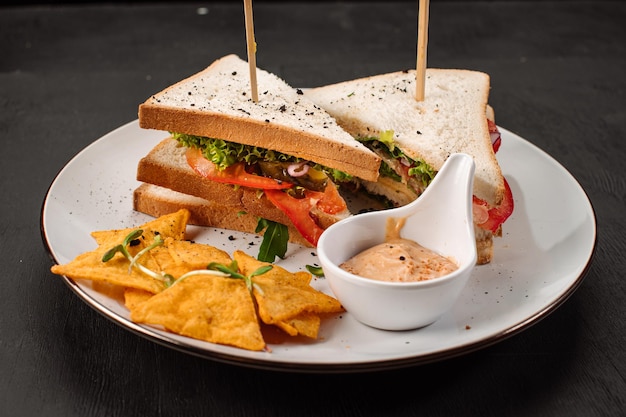 Tasty sandwich with vegetables and herbs on wooden background