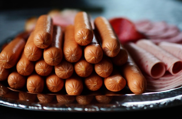 Вкусные колбасы и овощи, выделенные на твердом фоне Фотографии еды для ресторанов и кафе