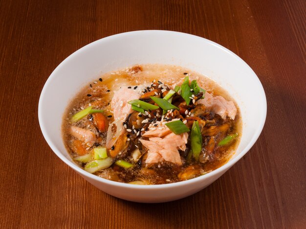 Tasty Shanghai soup with mussels and fish in a white bowl