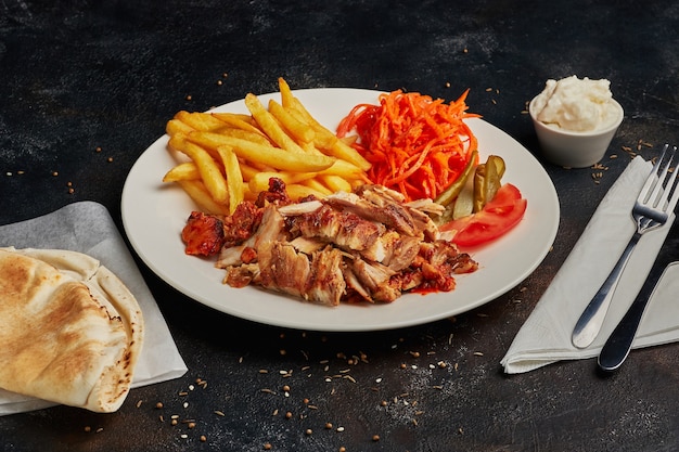 Gustoso shawarma con patate fritte su sfondo scuro