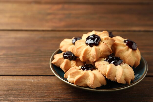 Foto deliziosi biscotti con marmellata su un tavolo di legno