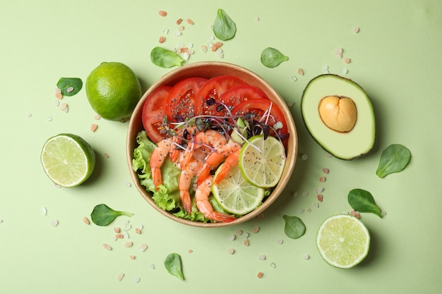 Tasty shrimp salad on green background, top view