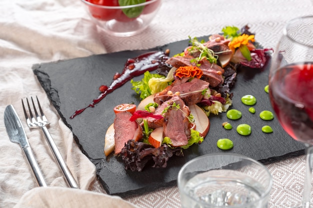 Tasty sliced roast duck breast with fresh vegetable salad