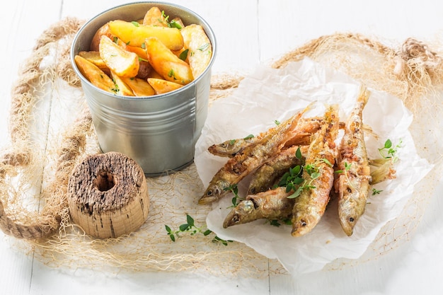 Tasty smelt fish and chips with herbs and salt