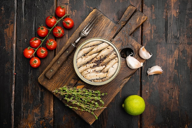 맛있는 훈제 생선, 기름에 든 정어리 통조림, 오래된 어두운 나무 탁자 배경, 위쪽 전망, 텍스트 복사 공간