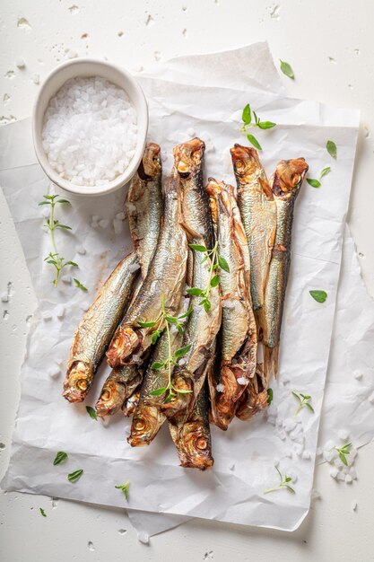 Tasty smoked sprats on white food paper