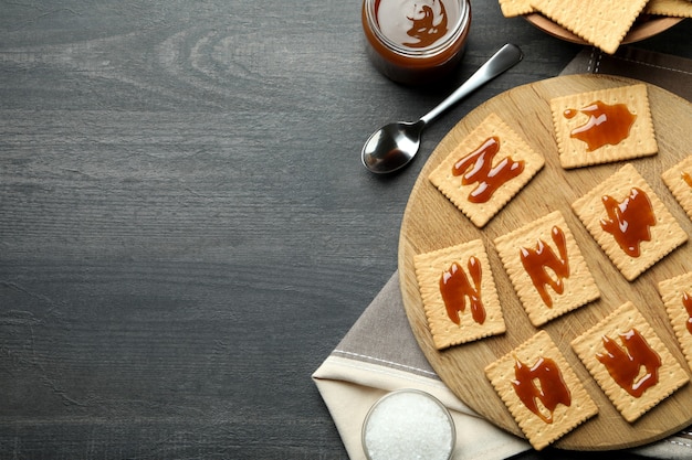 Tasty snack concept with cookies with caramel on dark wooden table