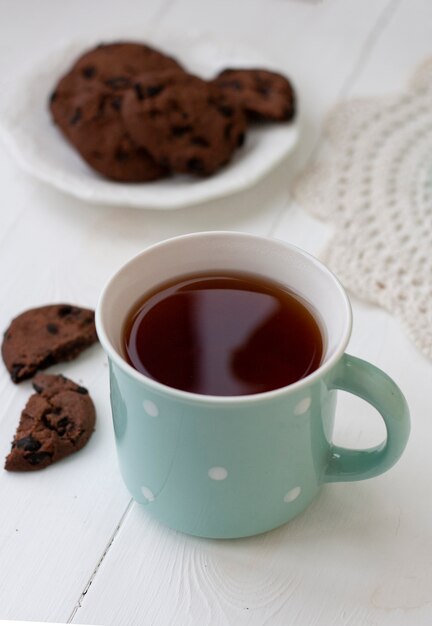 A tasty snack: a cup of tea and a plate of cookies.