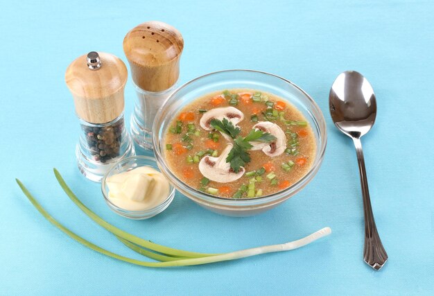 Tasty soup on blue tablecloth