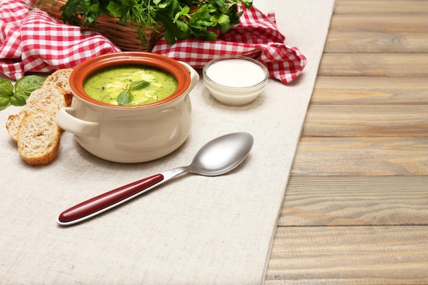 Вкусный суп в кастрюле на деревянном столе крупным планом