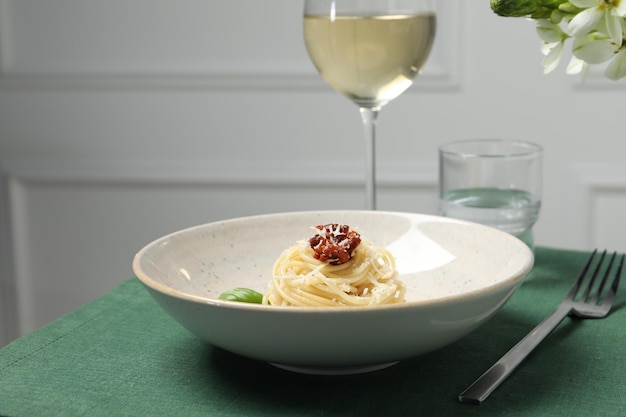 Tasty spaghetti with sundried tomatoes and parmesan cheese served on table closeup Exquisite presentation of pasta dish