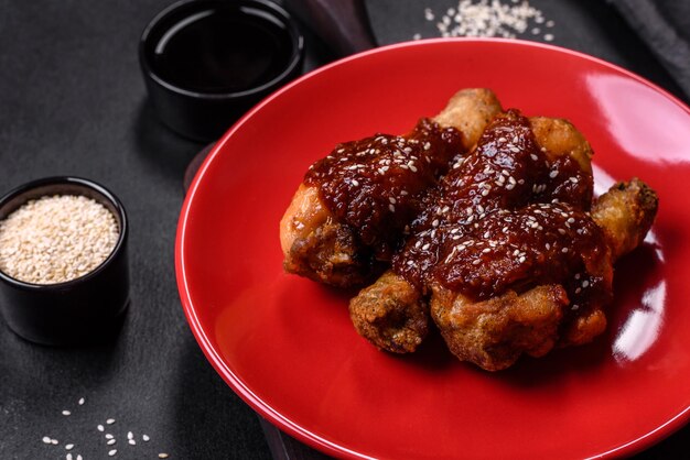 Photo tasty spicy chicken legs with teriyaki sauce and sesame seeds