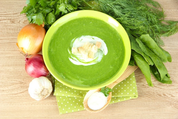 Tasty spinach soup on wooden table