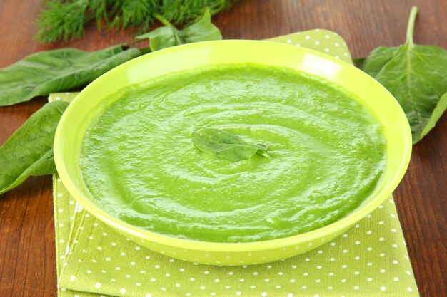 Tasty spinach soup on wooden table