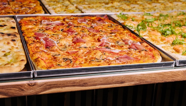 Tasty square pizzas on metal trays