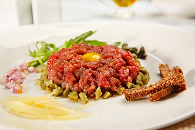 Tasty steak tartar on white plate