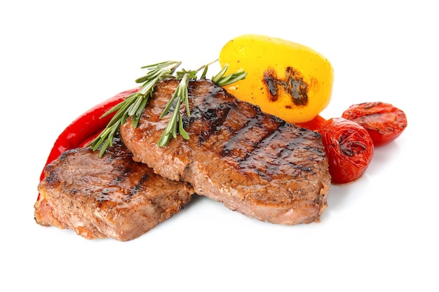 Tasty steaks with vegetables on white background