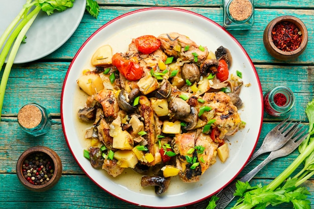 Gustoso stufato o ragù con carne di pollo e verdure su un vecchio tavolo di legno