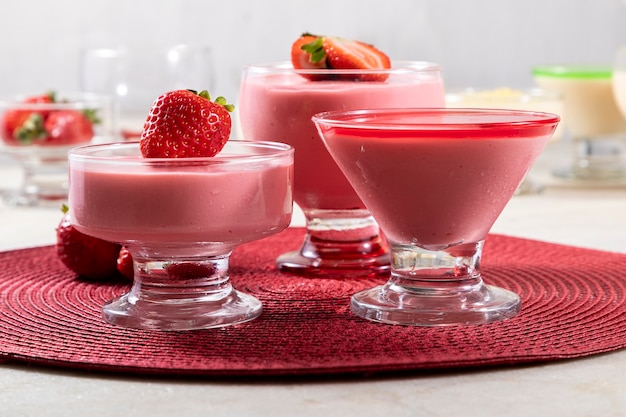 Tasty strawberry mousse in glass with gelatin on top.