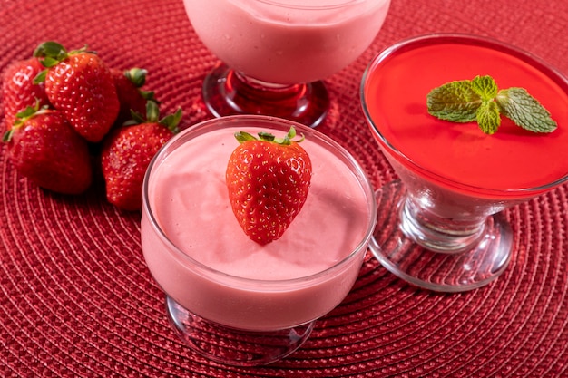 Tasty strawberry mousse in glass with gelatin on top.