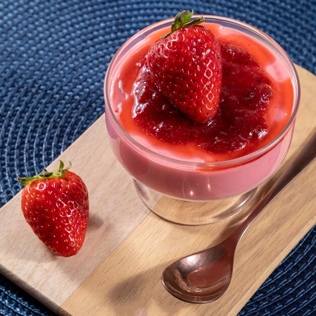 Tasty strawberry mousse in glass with jam on top.