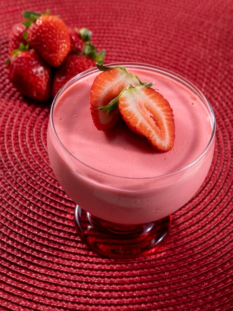 Tasty strawberry mousse in glass with strawberry on top.