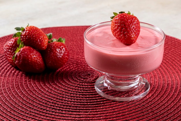 Tasty strawberry mousse in glass with strawberry on top.