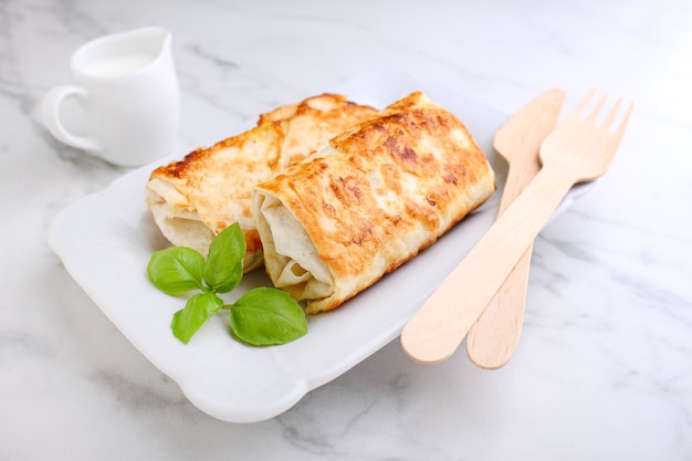 Gustose frittelle ripiene di crepes con carne e salsa e basilico. fotografia di cibo.