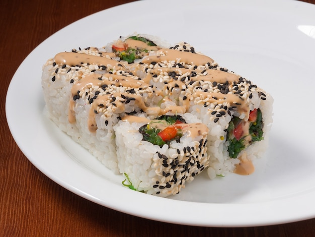 Tasty sushi roll with Chuka seaweed on a white plate