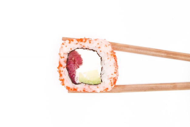 Tasty sushi roll with wooden chopsticks on white background