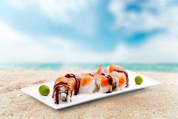 Tasty Sushi rolls on plate on light background