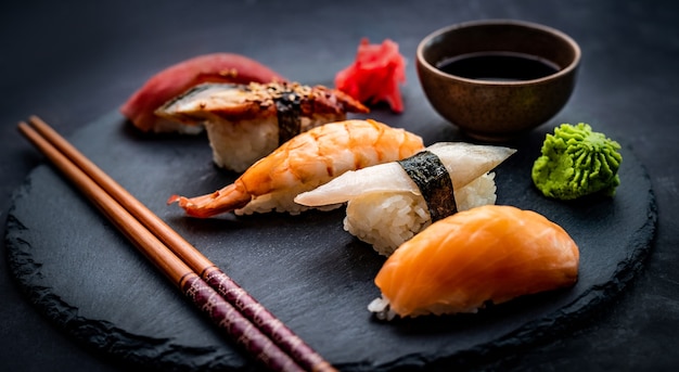 Tasty sushi sashimi set composition with shrimps ginger and soy sauce served with chopsticks and gre...