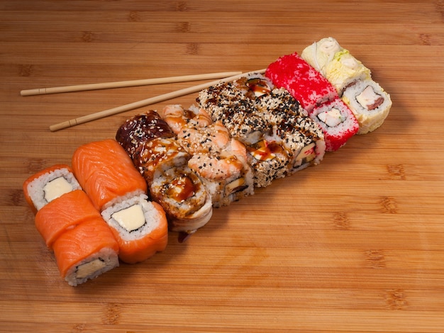 Tasty sushi set and sushi roll on wooden board