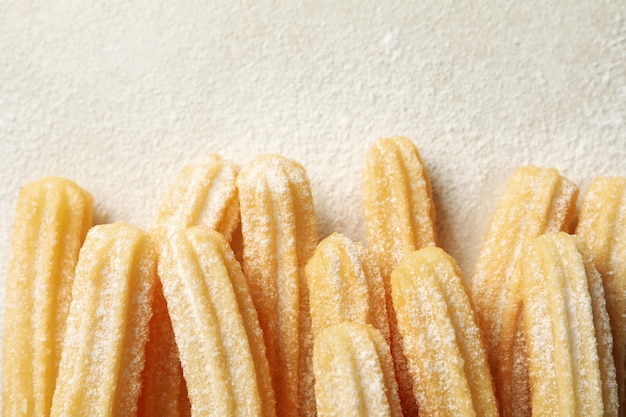 Tasty sweet churros on gray background