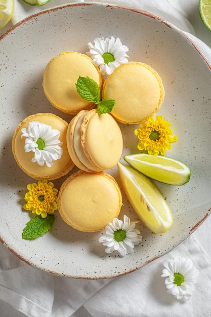 Tasty and sweet lemon macaroons with spring flowers on plate